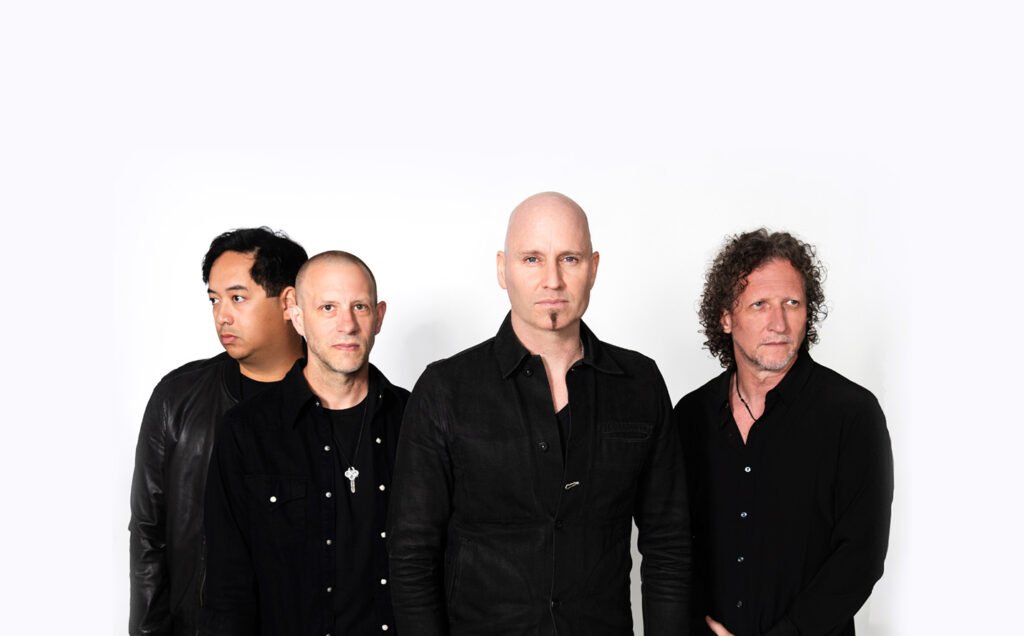 Members of Vertical Horizon standing together all wearing black shirts and looking in different directions.